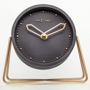 Cross Table in black with rose gold numbers and hands, resting on a simple metal stand