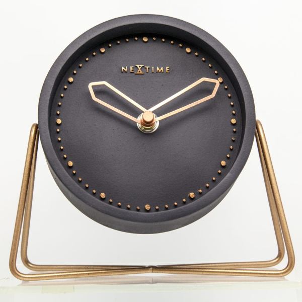 Cross Table in black with rose gold numbers and hands, resting on a simple metal stand