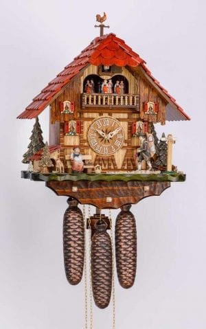 Red roof tiles and a cockerel weather vane top this traditional bavarian chalet, where a pedlar tries to sell his wares to the elderly occupant.