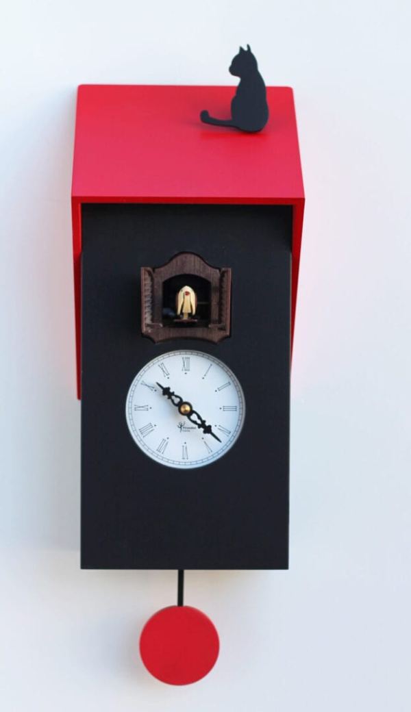 Cucu Vicenza is a super cuckoo clock in black with a red roof, on which sits a black cat. The cuckoo appears from a small house above the white clock face