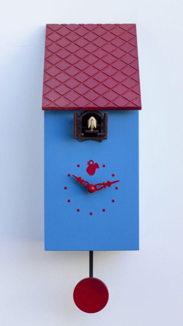 A cute blue cuckoo clock which looks like a bird house. The clock has red hands and dots for numbers, with a little cuckoo house just under the eaves of the red roof.