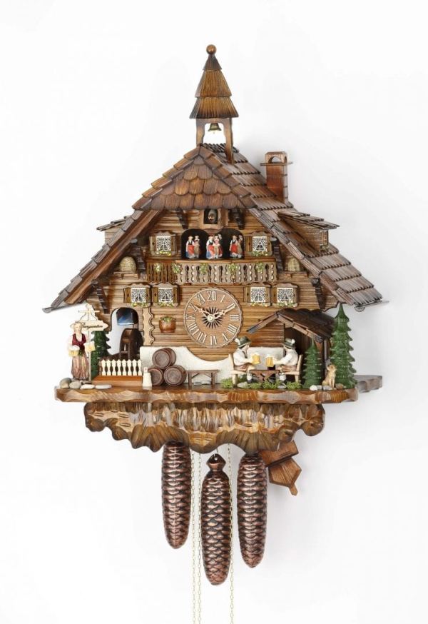 Beer drinkers sit in front of the chalet, which is ornate and has a bell tower to the top