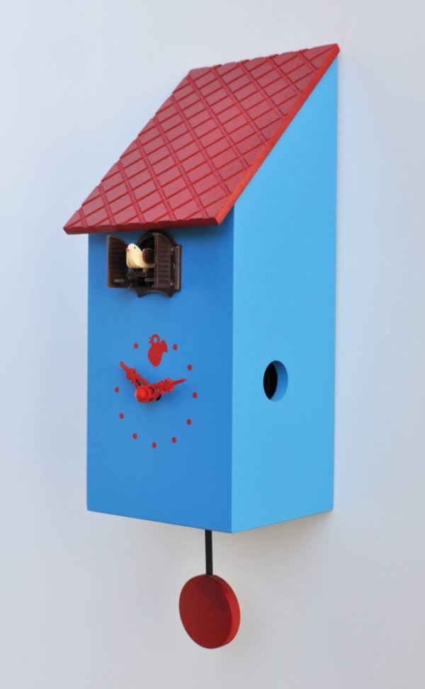 Side view of the portofino blue cuckoo clock with a red roof and detail. The clock has a red pendulum