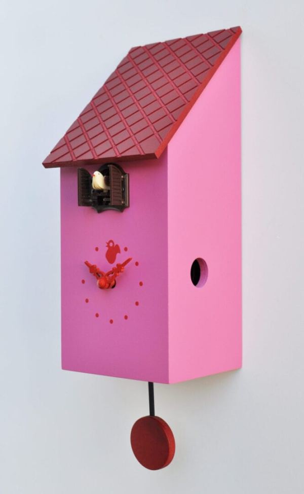 Side view of a cuckoo clock in the form of a bird house, in pink with red roof