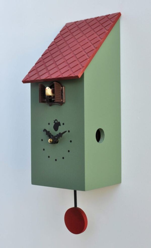 A obtuse view of the green version of the portofino cuckoo clock which resembles a bird house, with a red roof and pendulum, black detailing
