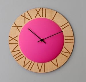 Roman numerals etched onto wood, highlighted by the fuschia pink central circle