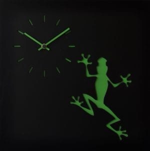 A green frog adorns this black clock, with matching green clockface and hands