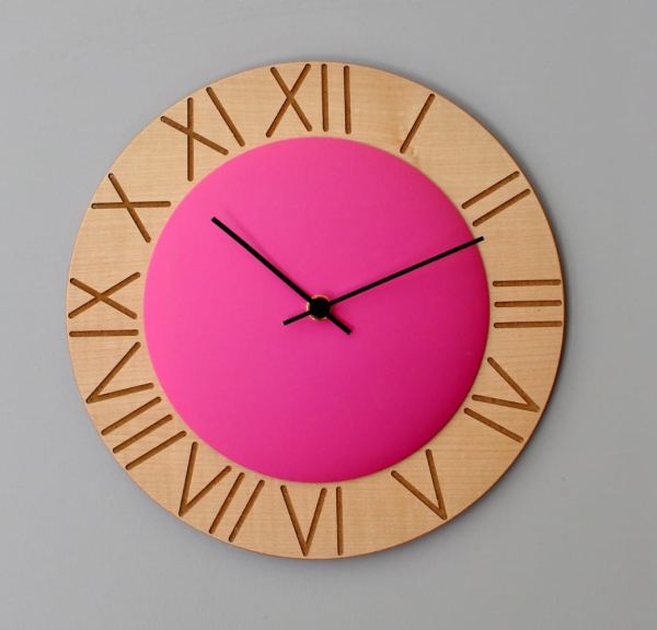 Roman numerals etched onto wood, highlighted by the fuschia pink central circle