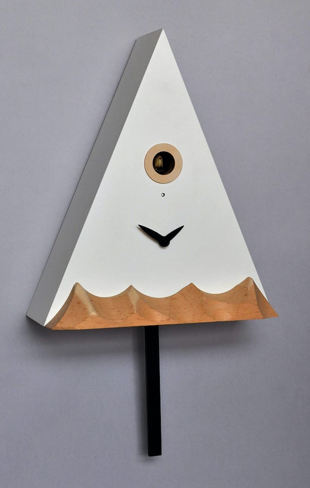 a clock in the form of a mountain peak, with lower mountains carved in natural wood