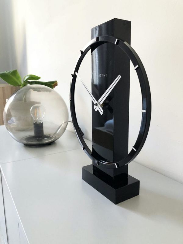 Carl clock, a black ring suported on a black wooden pillar. The clock has white hands and hour markers