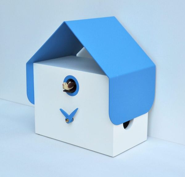 Side view of the Dotto cuckoo clock, shown in white with a blue metal roof and blue trim