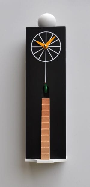 The Ziggurat cuckoo clock in black - a rectangular box forms the case, with a birchwood ladder leading to the cuckoos house just under the white clock markings, which has orange hands.