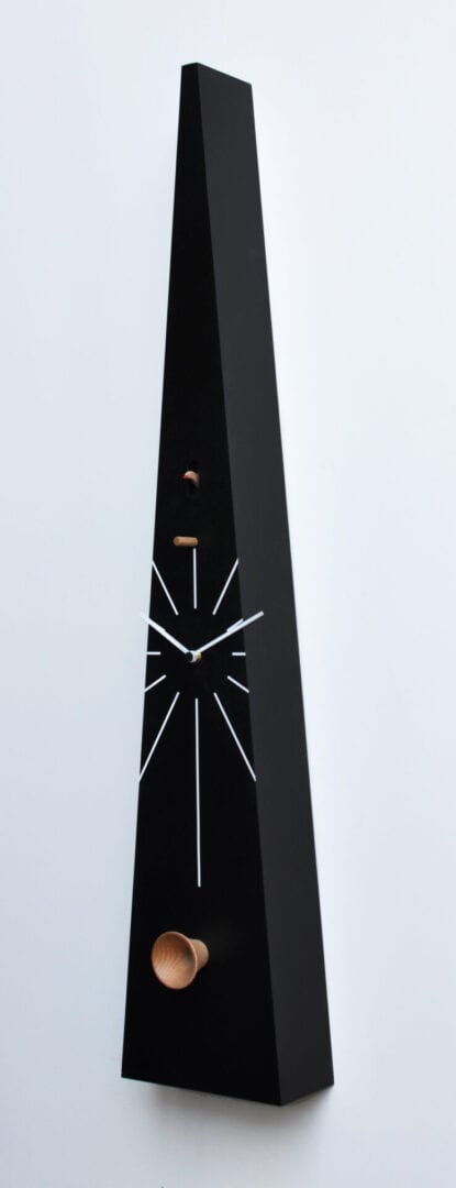 Nero Tall cuckoo clock from the right, showing a very tall and narrow triangular shaped clock with white markings and a handcarved cuckoo