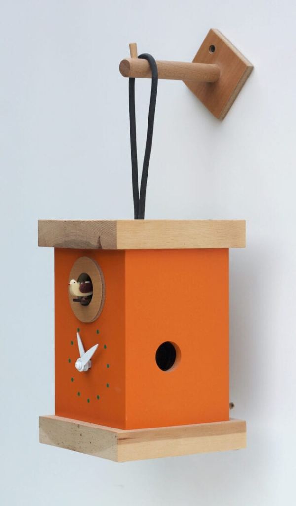 Side view of titti cuckoo clock in orange-yellow, with pine trim and a hanging loop