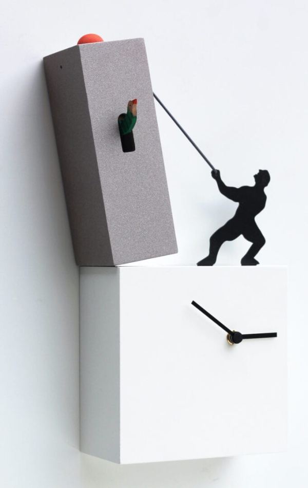 Lo Tengo is a cuckoo clock full of fun and humour - a silhoutte of a figure which uses a rope to hold the toppling tower which containing the cuckoo element of the clock. The figure is standing on the lower element of the clock which has the clock face in white.