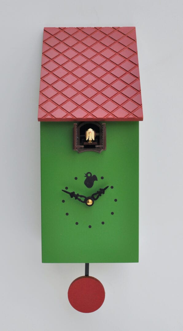 Portofino cuckoo clock in green with burgundy textured roof and pendulum and black detail on clockface. The cuckoo appears from its home under the roof.