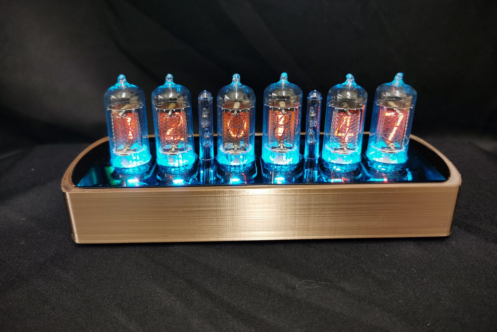 Genesis GS gold and smoked 3D printed nixie clock with gold coloured gase, and blue backlit tubes showing the date in this instance