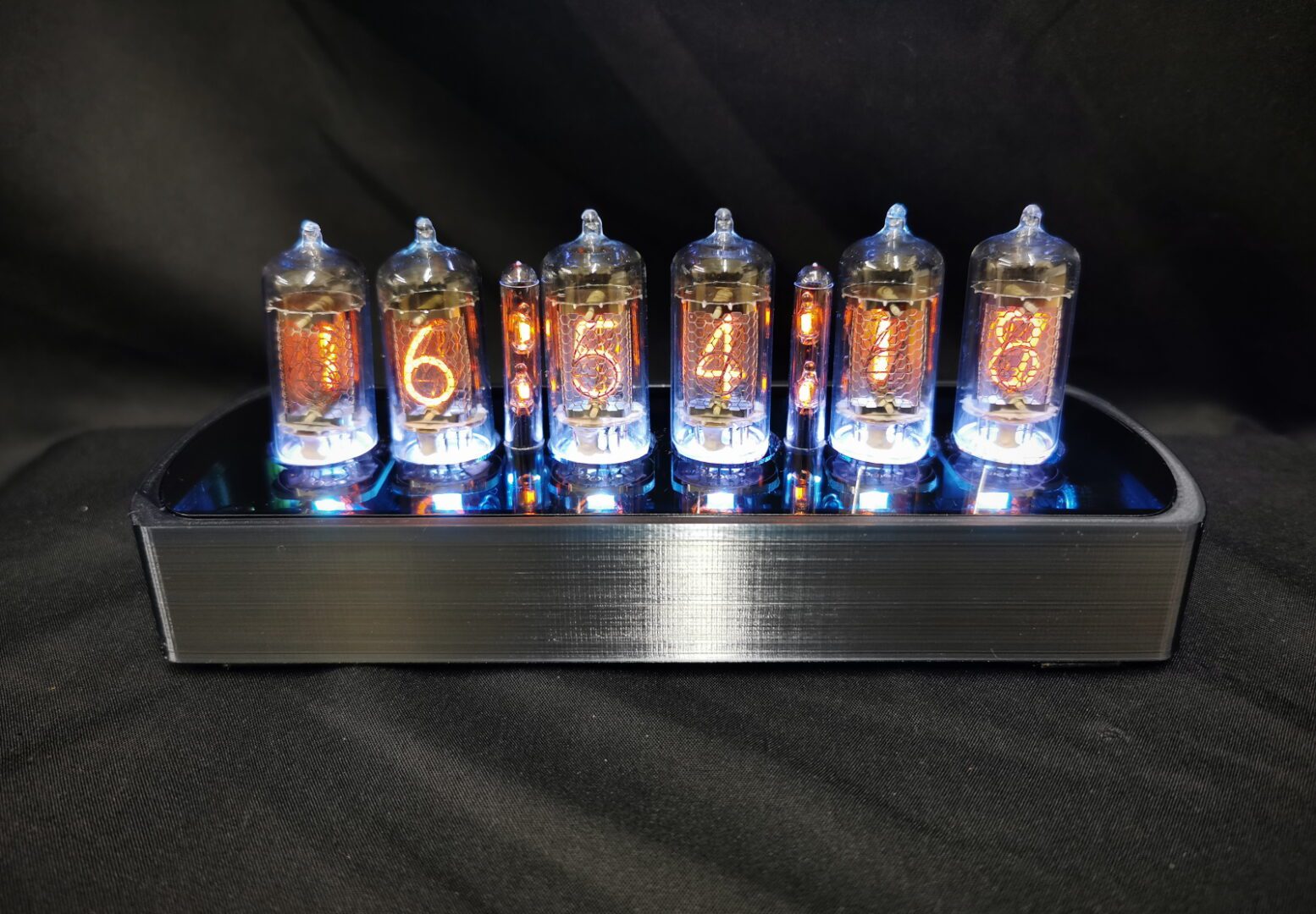 Genesis CS - black chrome coloured case with blue back lit nixie tubes, viewed from the front