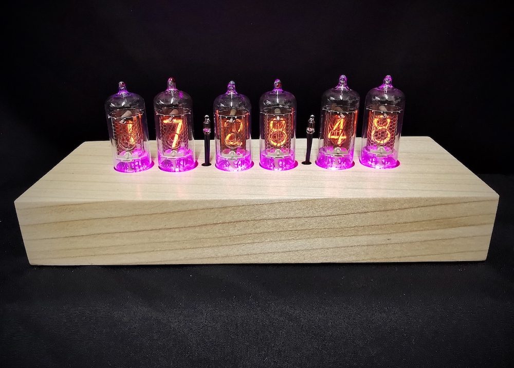 Front view of cadence tulipwood clock, backlit in pink