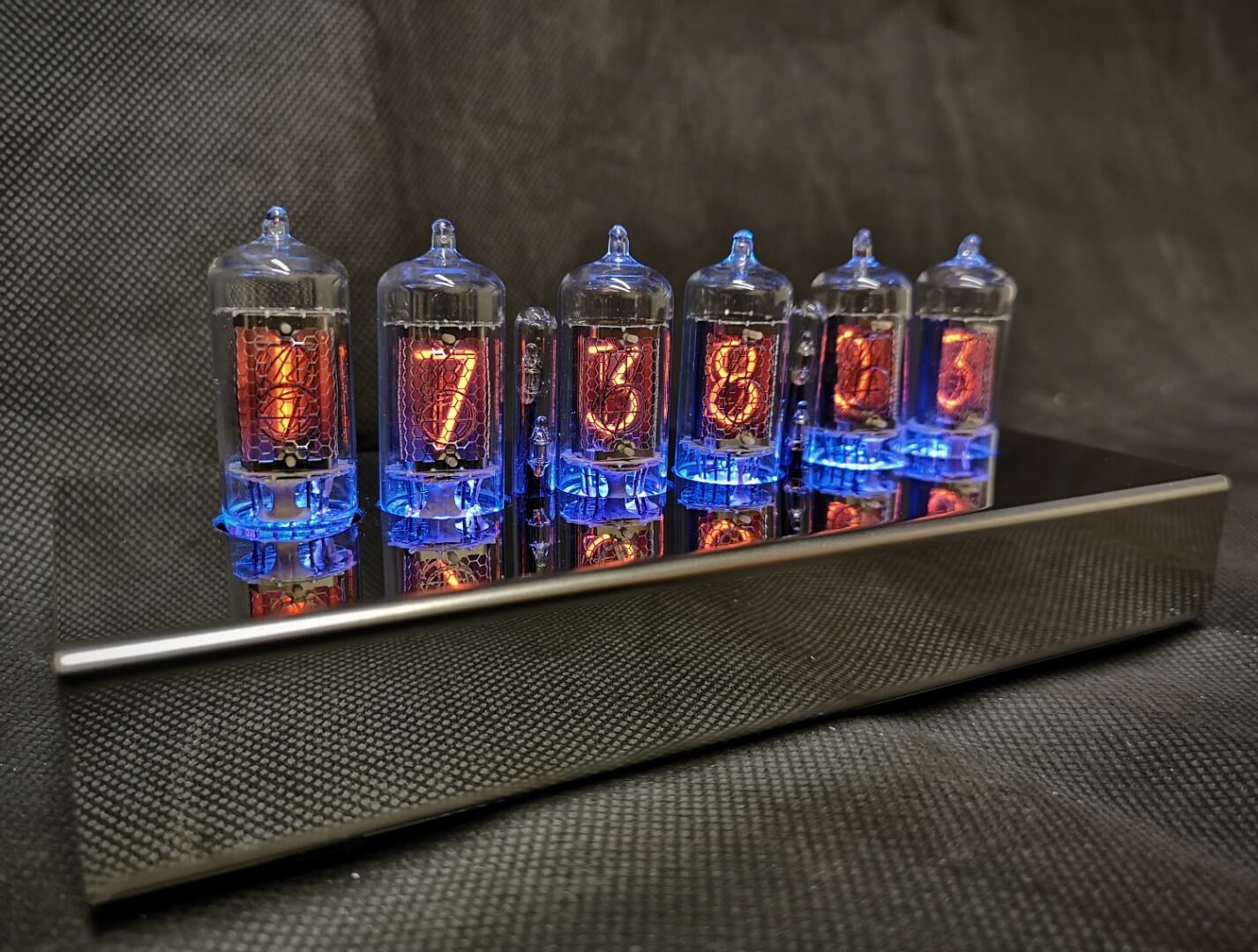 T1000 Nixie clock showing blue lighting theme, with 6 nixie tubes used for time and date, in a stainless steel case