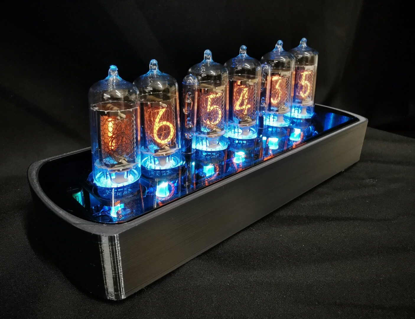 viewed from the side, genesis cs in black chrome, with blue back lit nixie tubes