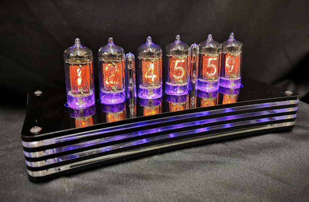 humbug digital tube clock showing purple and orange colorways, which are picked up buy the layered acrylic case