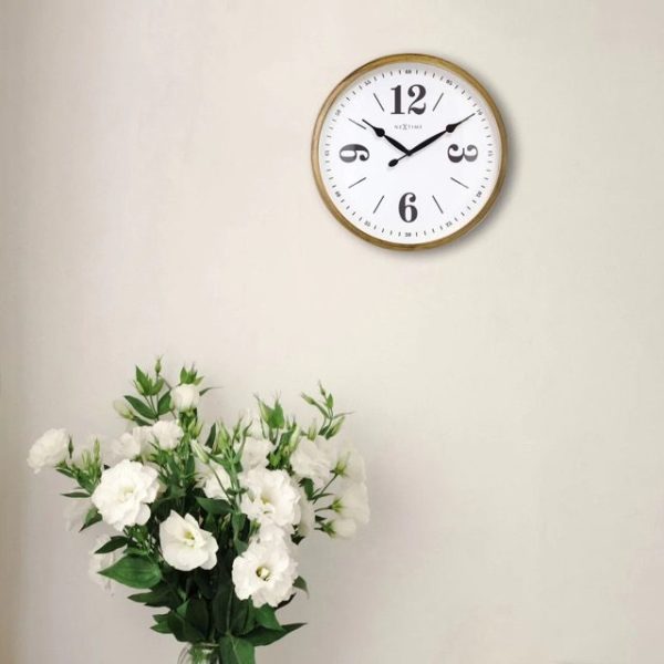 Classic wall clock with white face, black numbers and hands and vintage gold case, shown against a cream coloured wall with a vase of cream flowers on display