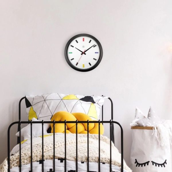 Mix wall clock shown in a room setting with black bed frame and coloured bed linen
