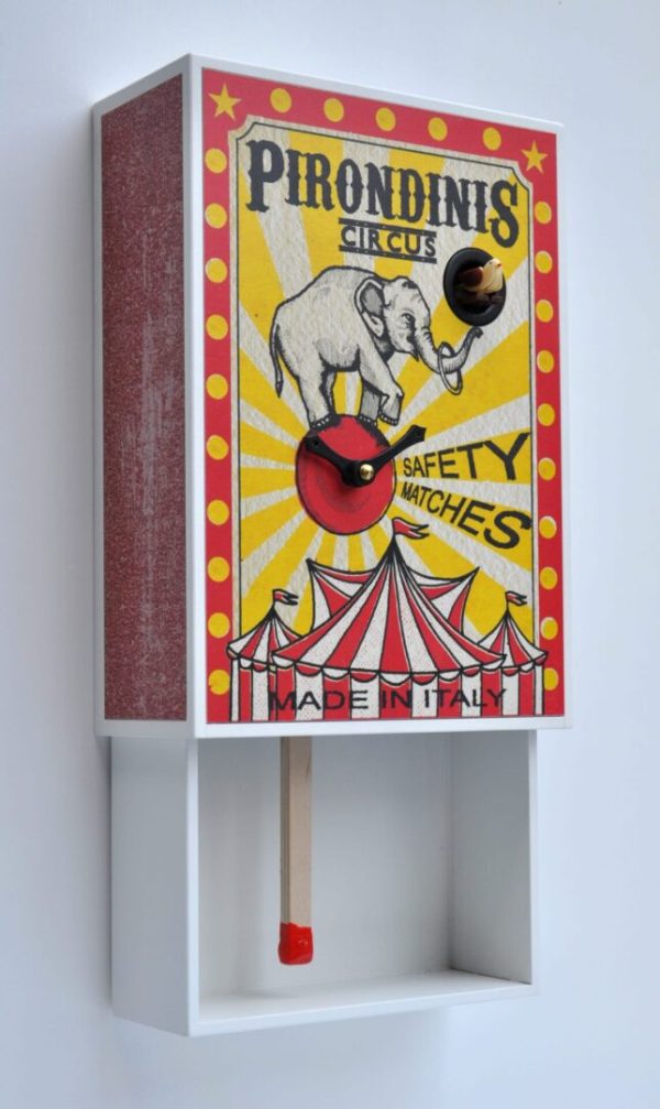 Side view of matchbox style clock, showing elephant in circus environment.