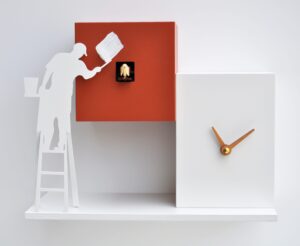 Painter silhouetted against a cubic cuckoo clock