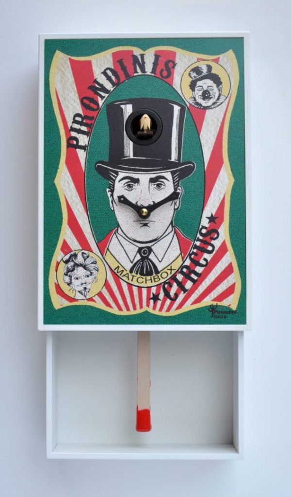 A cuckoo clock in the style of a matchbox, with a matchstick forming the pendulum within the drawer. The front of the matchbox shows the ringmaster, complete with top hat.