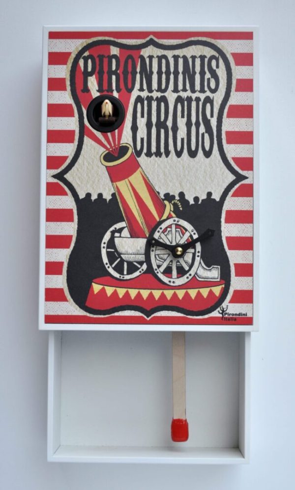 A fun and unusual cuckoo clock in the form of a matchbox, the image showing a circus cannon in retro style. The opened 'matchbox' has a match stick for a pendulum.