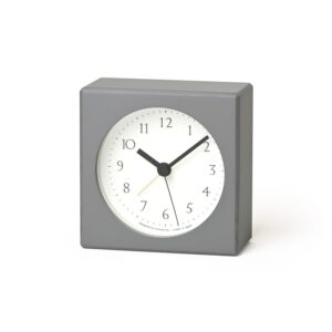 Grey Nuan alarm clock, a small clock made of beech wood and finished in a grey laquer. The clock face is white and the hands and numbers are black.