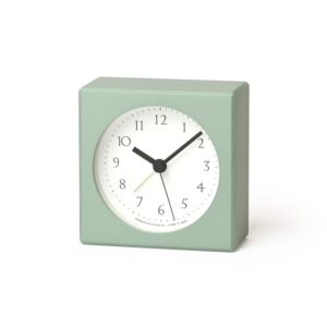 A green coloured alarm clock with round face in white with black numbers and hands
